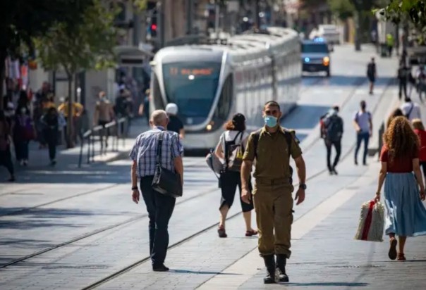 Orang-orang Yerusalem yang mengenakan masker wajah karena takut virus corona berjalan di jalan Jaffa di Pusat Kota Yerusalem pada 12 Juli 2020. Israel telah melihat lonjakan kasus COVID-19 baru, menteri kabinet memberlakukan pembatasan baru pada pert