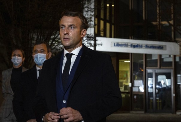 Presiden Prancis Emmanuel Macron, diapit oleh Menteri Dalam Negeri Prancis Gerald Darmanin, kedua kiri, berbicara di depan sebuah sekolah menengah pada Jumat 16 Oktober 2020 di Conflans Sainte-Honorine, barat laut Paris, setelah seorang guru sejarah 