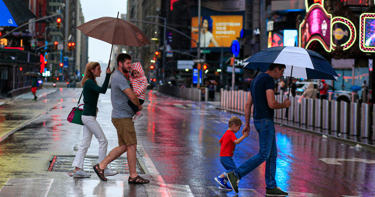 Orang-orang menyeberang jalan saat hujan turun di Times Square saat Badai Tropis Henri mendekat, New York, 22 Agustus 2021.(FOTO/Alajazeera )