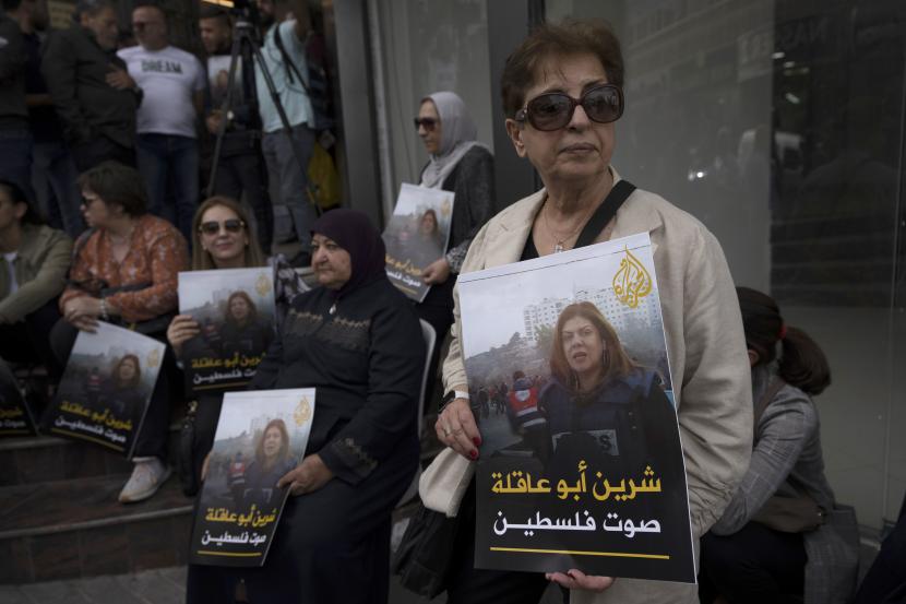 Para pelayat Palestina membawa foto jurnalis Aljazirah yang terbunuh Shireen Abu Aklehdi depan kantor saluran Aljazirah, di kota Ramallah, Tepi Barat, Rabu, 11 Mei 2022. Foto: AP 