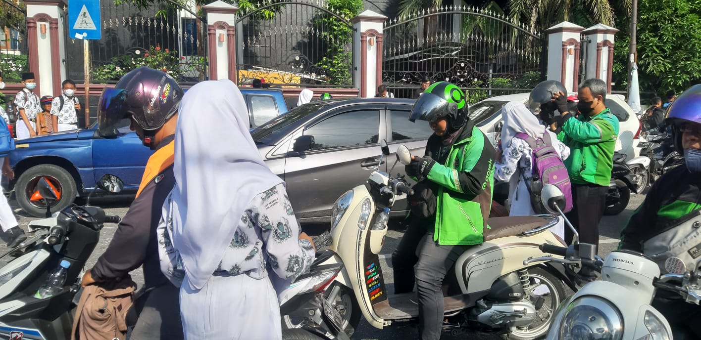 Tampak seorang remaja perempuan dibantu berkemas untuk naik ke kendaran motor gojek di wilayah kawasan pendidkan Kota Pekanbaru, baru-baru ini.( FOTO/SRc)